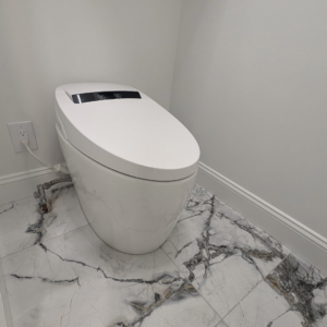 A modern smart toilet installed on new marble-look tiled flooring by Ensotile - Atlanta Bathroom Remodeling in Stone Mountain, GA