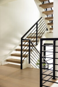 A modern staircase featuring wooden treads and black metal railings, installed by Northrup Remodeling in Minneapolis, MN