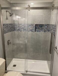 A modern tiled shower with a glass enclosure, showcasing a bathroom remodel by DCM Multi Service llc in Harrisburg, PA.