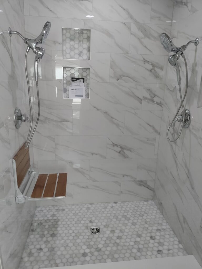 A modern tiled walk-in shower with built-in shelves and two shower heads, showcasing a completed project by Devco Construction LLC in West Valley City, UT.