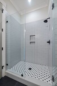 A modern tiled walk-in shower installation with glass enclosure by Orival Property Services in Boston, MA.