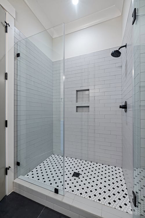 A modern tiled walk-in shower installation with glass enclosure by Orival Property Services in Boston, MA.