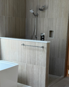 A modern walk-in shower with wood-grain tile installation by Nelson Tile and Stone in Bend, OR.
