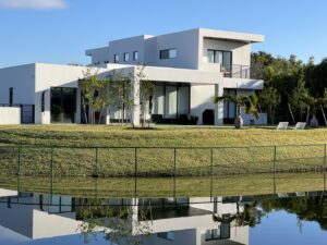 The sleek exterior of a modern waterfront home with large windows and a flat roof by Madison Construction Group, Inc. in Miami, FL