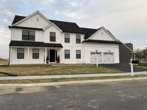 A modern farmhouse-style new construction home with white siding and black windows by Lancaster Home Builders in Lancaster, PA.