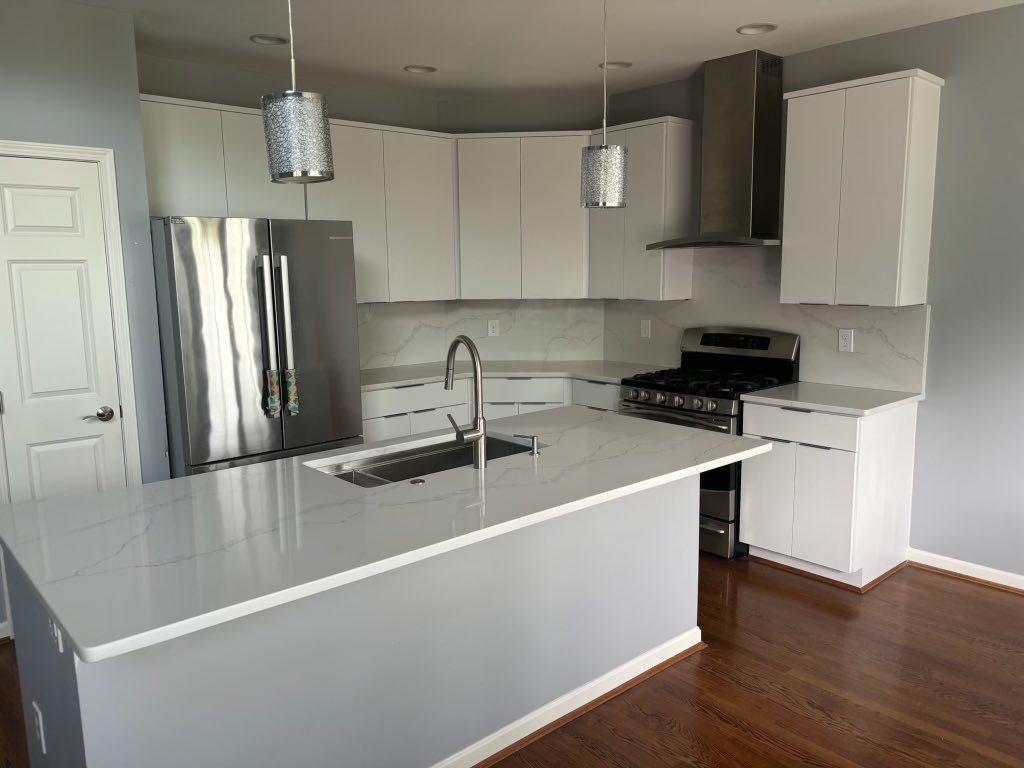 A beautifully refaced modern kitchen with white cabinets and a large island by Cincinnati Cabinet Refacing in Cincinnati, OH.