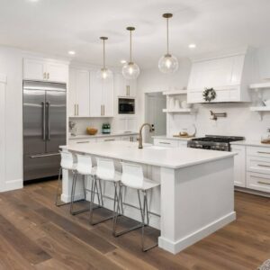 Modern white kitchen remodel with a large island, pendant lights, and stainless steel appliances by Corkery Customs & Remodeling LLC in Philadelphia, PA