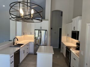 A bright, modern kitchen remodel with white cabinets and stainless steel appliances by Centennial Builders, LLC in Litchfield Park, AZ.