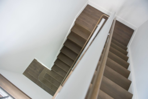 A modern wooden staircase with a sleek railing, expertly installed by MTI Carpentry in Jersey City, NJ.