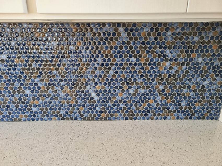 Close-up of a colorful mosaic penny tile kitchen backsplash installed by Bryan's Home Services in Fargo, ND.