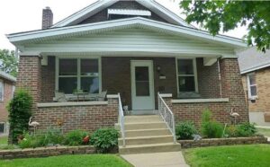 A residential roof heavily covered in moss, indicating a need for cleaning or repair by Spartan Roofing LLC in St. Louis, MO