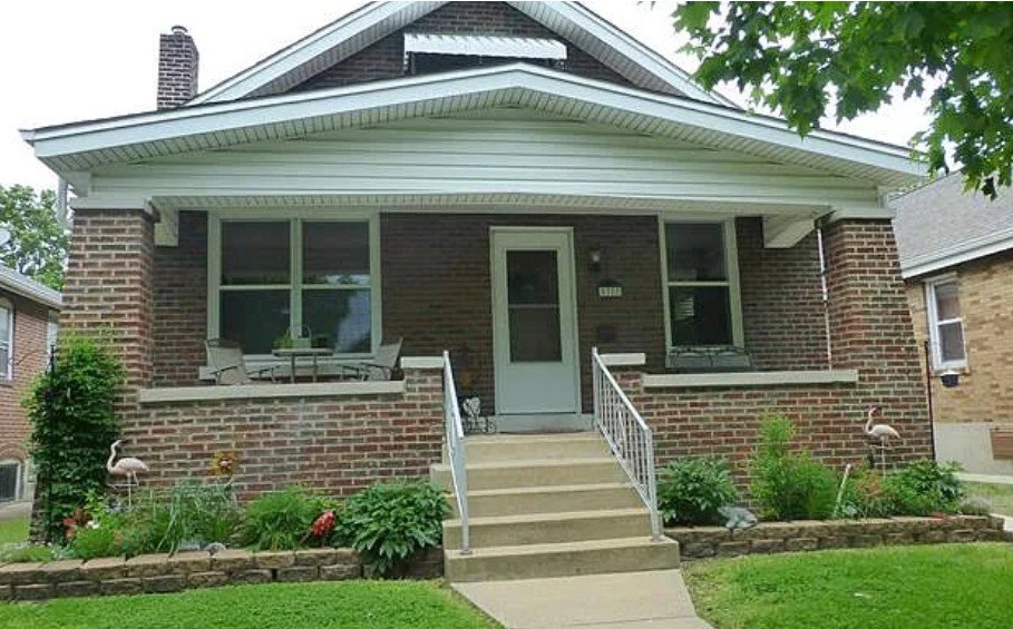 A residential roof heavily covered in moss, indicating a need for cleaning or repair by Spartan Roofing LLC in St. Louis, MO