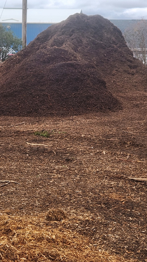 A mountain of dark, rich mulch ready for landscaping projects from Lp Tree Service in Janesville, WI