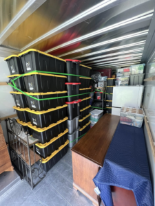 A moving truck interior packed with storage bins and furniture by Hill & Sons Hauling LLC in Virginia Beach, VA.