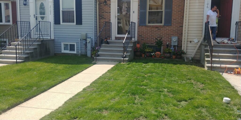 A neatly mowed lawn and freshly mulched garden beds in front of a house, by C&C LAWN CARE,MOVING & TRASH REMOVAL in Baltimore, MD
