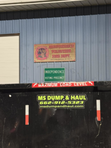 An MS Dump & Haul branded dumpster positioned outside a commercial building in Hernando, MS, ready for junk removal.