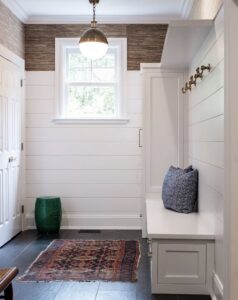 A renovated mudroom featuring a built-in bench, coat hooks, and shiplap walls, completed by Home Made Easy in Norwalk, CT.