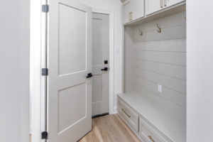 A custom mudroom with built-in bench, storage, and coat hooks installed by LP Home Builders in Houma, LA.