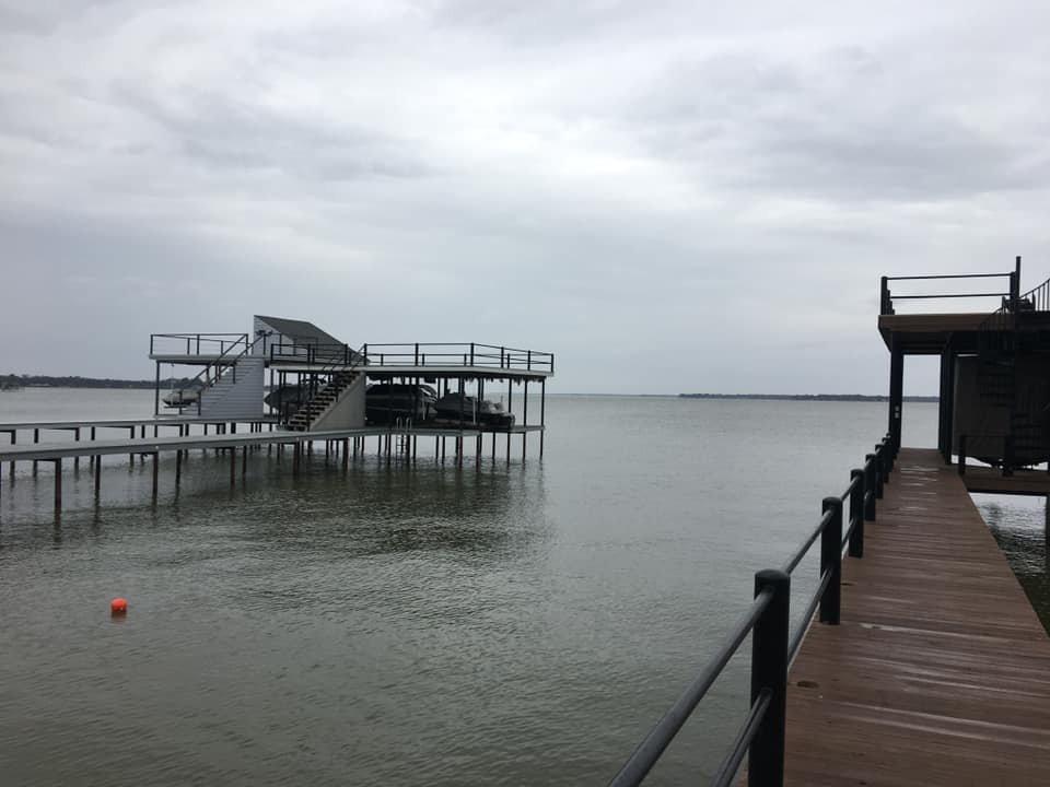 A newly constructed multi-level boat dock and pier on a lake by TYCO Roofing & Construction LLC in Allen, TX.