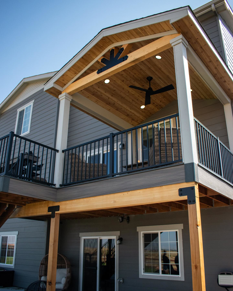 A multi-level deck with a covered patio, ceiling fan, and recessed lighting by TNC Builders, LLC in Aurora, CO