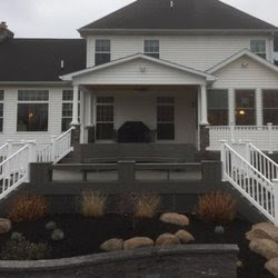 A beautifully designed multi-level deck and patio with professional landscaping by Pink Rose Home Service in Rochester, NY.