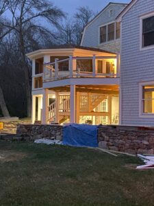 A multi-level deck with a screened-in porch addition by Wood Trades LLC in Westport, MA.