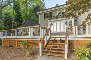 A multi-level wooden deck with stairs and horizontal slat skirting built by Constructive Design Group in Raleigh, NC