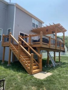 A multi-level wooden deck featuring stairs and a pergola, expertly built by McIntosh Construction in Des Peres, MO.