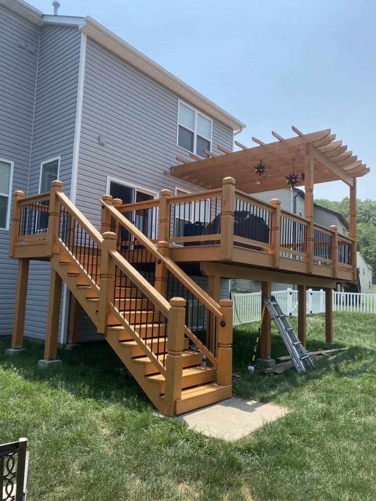 A multi-level wooden deck featuring stairs and a pergola, expertly built by McIntosh Construction in Des Peres, MO.