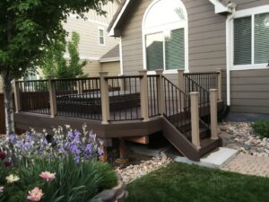 A multi-level deck with stairs and black metal railings, expertly installed by Lnk Deck & Remodels, LLC in Aurora, CO.