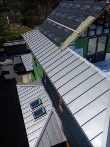 Multi-level metal roof installation in progress on a residential building by JB Home Improvement Services in Sanford, FL.