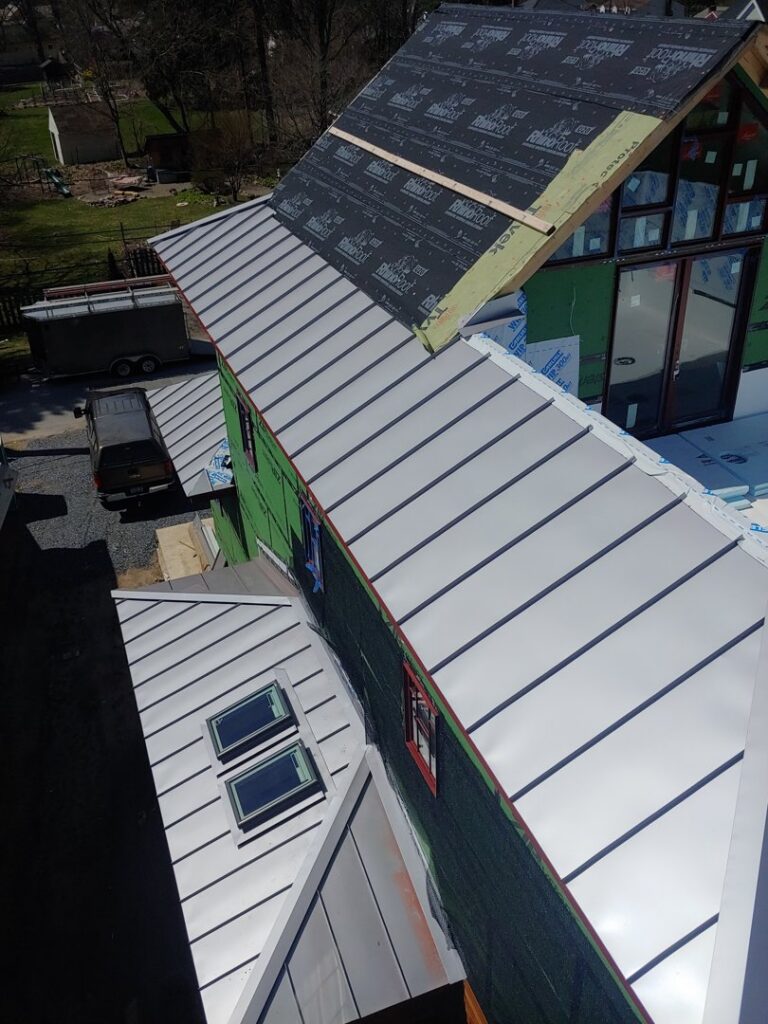 Multi-level metal roof installation in progress on a residential building by JB Home Improvement Services in Sanford, FL.