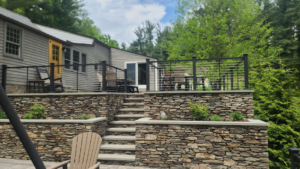 A multi-level patio featuring stone retaining walls, steps, and cable railings by David Hayden Construction LLC in Danbury, CT.