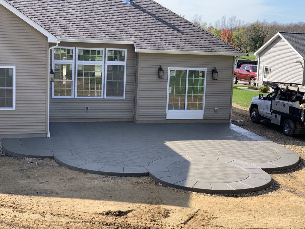 A large, multi-level patterned concrete patio next to a house, completed by Paris Brothers & Company, Inc in Erie, PA