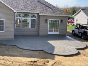 A large, multi-level patterned concrete patio next to a house, completed by Paris Brothers & Company, Inc in Erie, PA
