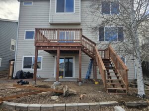 A large, multi-level wooden deck with stairs attached to a house, built by Jedi Bldrs in Colorado Springs, CO.