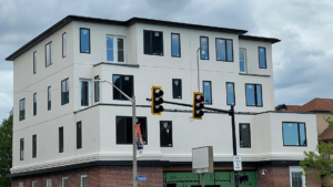 A multi-story building with a newly applied white EIFS or stucco exterior finish by WS Design Eifs-Stucco in Boston, MA.