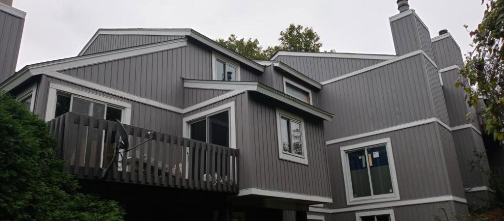 A multi-story building featuring new gray siding and white trim, a project by Mp painting and roofing LLC in Dayton, OH
