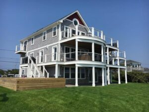 A multi-story home featuring new siding, extensive decking, and modern railings completed by Eagle Exteriors in Cumberland, RI.