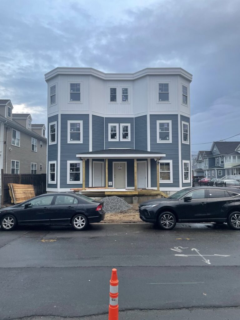 Multi-story residential building under construction with siding and windows installed by LCM FRAMING LLC in Danbury, CT