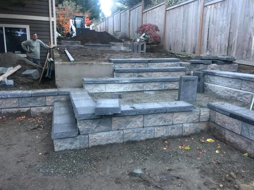 A multi-tiered retaining wall under construction by M.C.Dirtworks, a handyman service in Caldwell, ID.