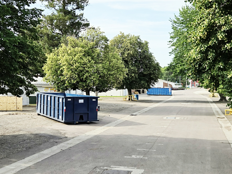 Multiple blue dumpsters placed in an outdoor area by Miedema Sanitation Inc of Huron SD in Mitchell, SD.