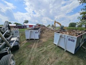 Multiple Bragg About This Dump roll-off dumpsters filled with demolition debris at a job site in Columbus, OH.