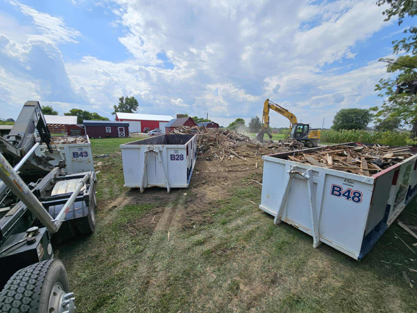 Multiple Bragg About This Dump roll-off dumpsters filled with demolition debris at a job site in Columbus, OH.