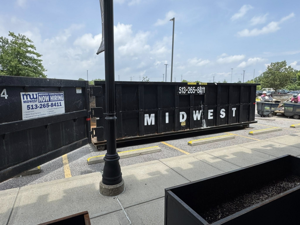 Multiple black Midwest Containers dumpsters in a parking lot, ready for junk removal services in Cincinnati, OH.