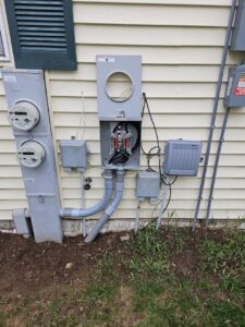 An exterior view of a house showing a setup with multiple electrical meters and conduits by Paramount Development in Milwaukee, WI.