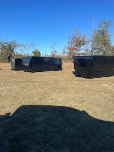 Multiple empty black dumpsters from Dumpster Dude ready for rental or placement in Amory, MS.