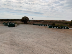 Multiple green dumpsters branded 'JORDAN' lined up on a gravel lot, indicating services by Jordan Disposal, LLC in Galena, KS.