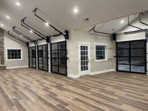 Multiple modern glass garage doors installed in a large interior space by Total Garage Works in Indian Trail, NC.
