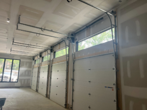 Multiple newly installed garage doors and tracks inside a modern garage by Advanced Garage Doors LLC in Alexandria, VA.